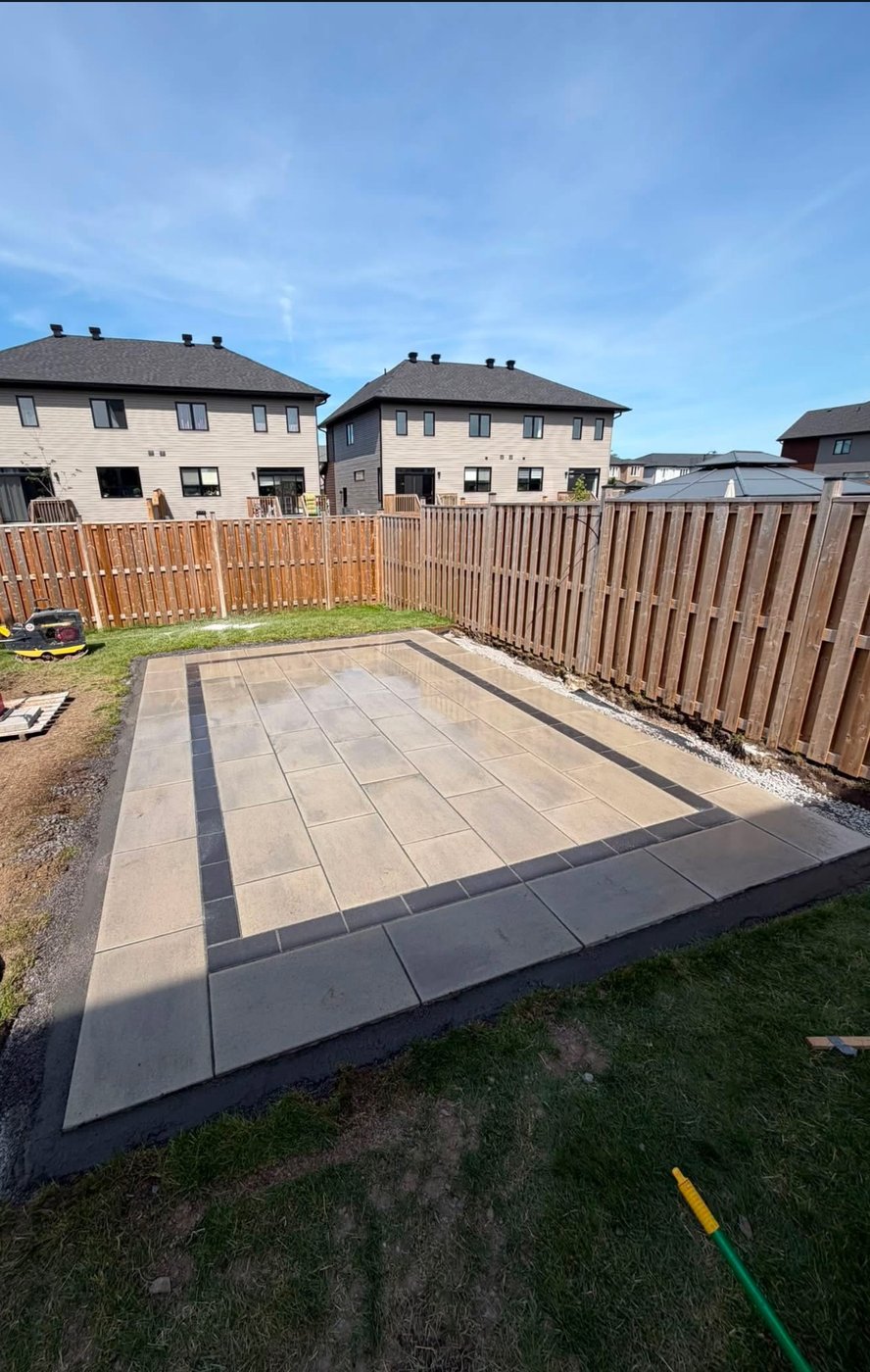 Finished two-tone interlock patio with contrast border, backyard install
