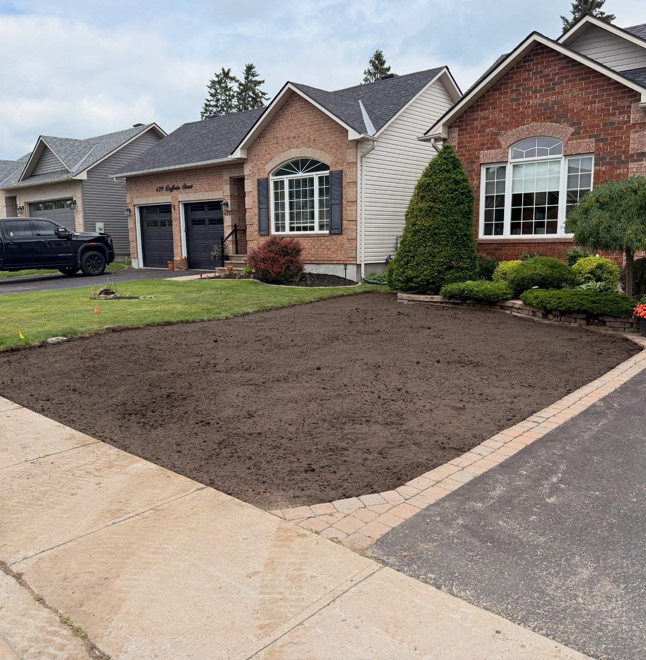 Fresh soil and sod prep along a front walkway and garden bed