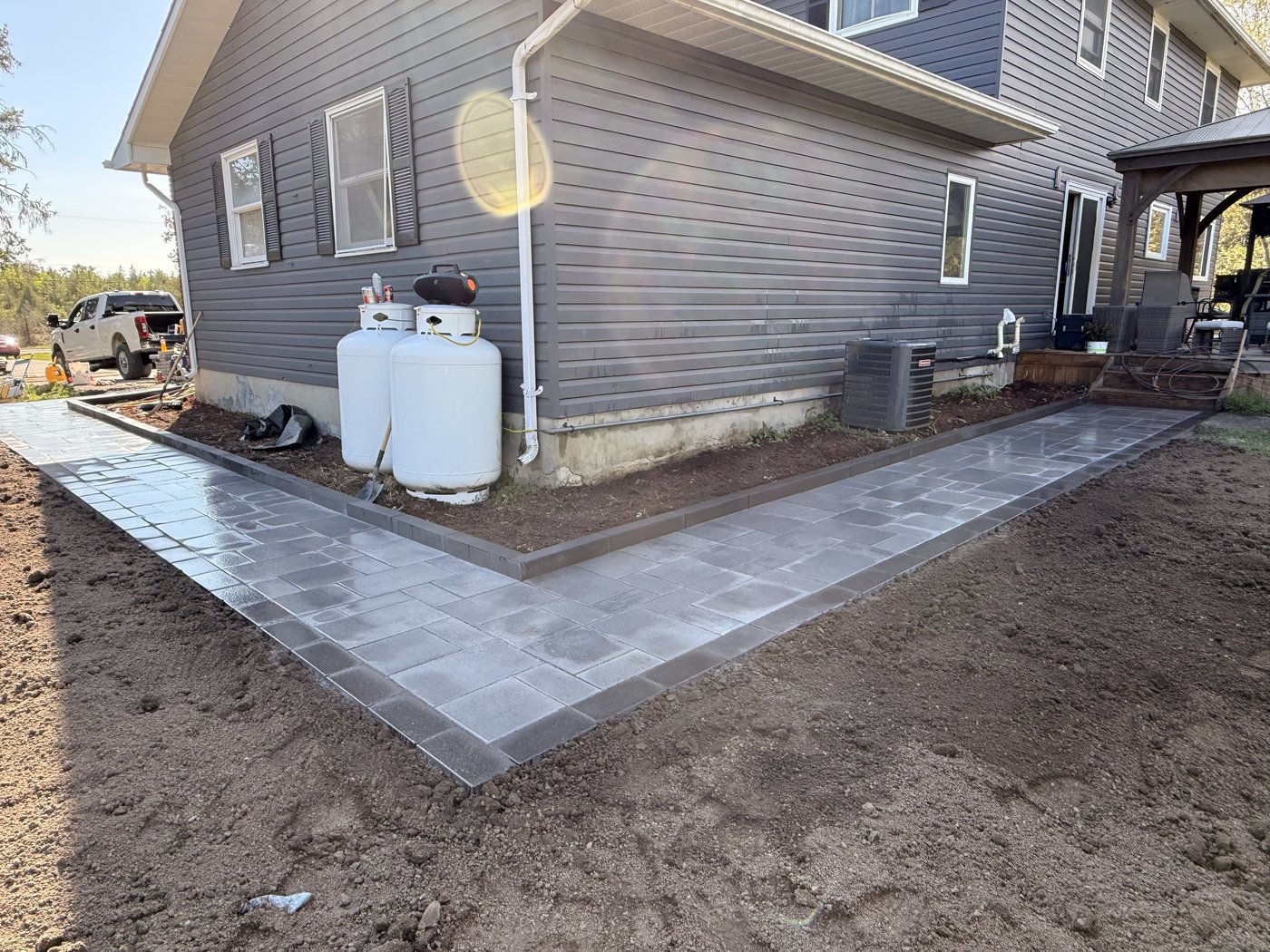 Finished paver walkway wrapping around the side of the house
