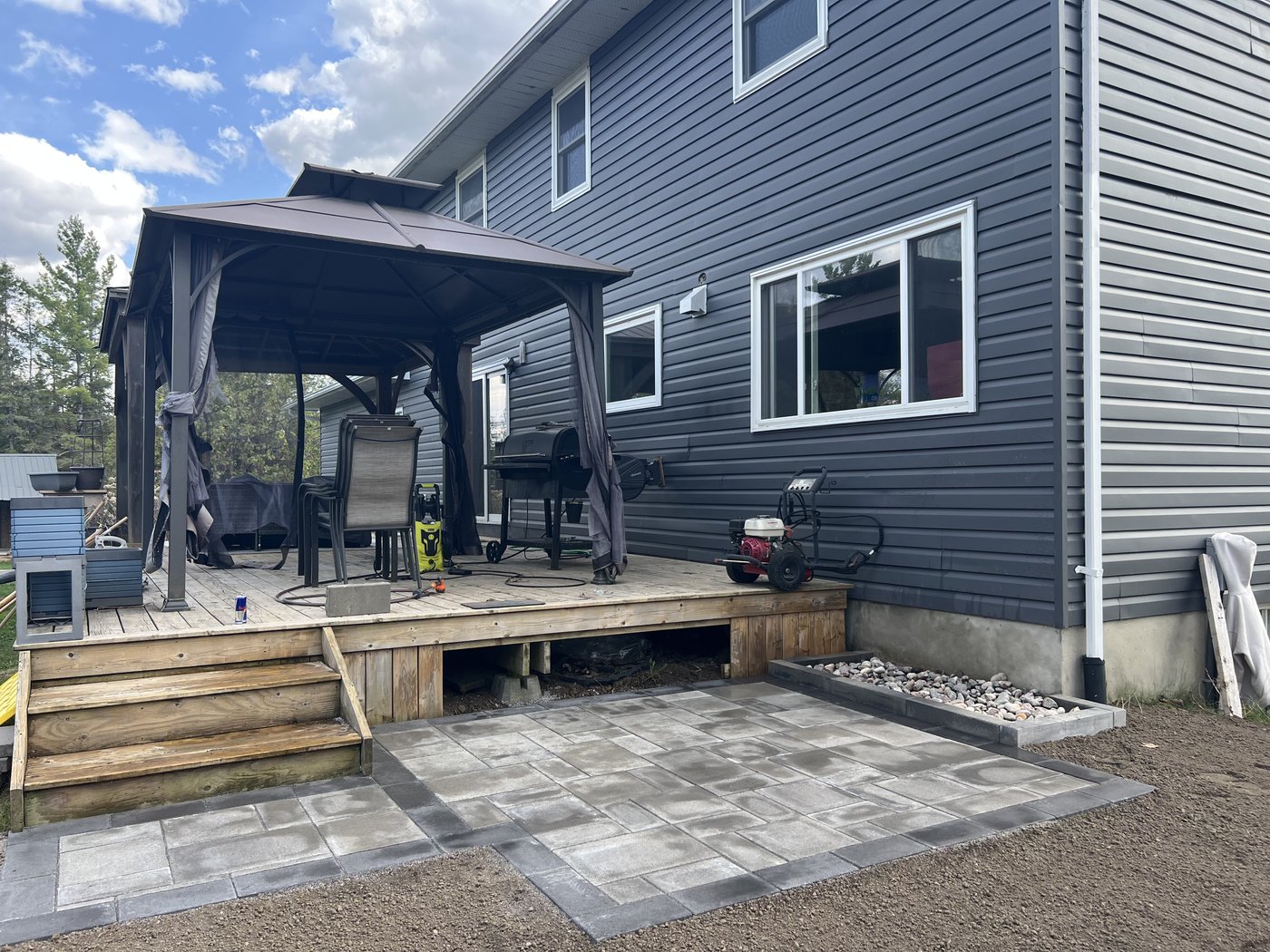 Finished patio off the deck with gazebo and seating area