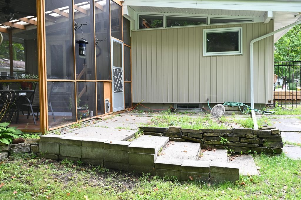 Worn concrete steps at the screened porch before replacement