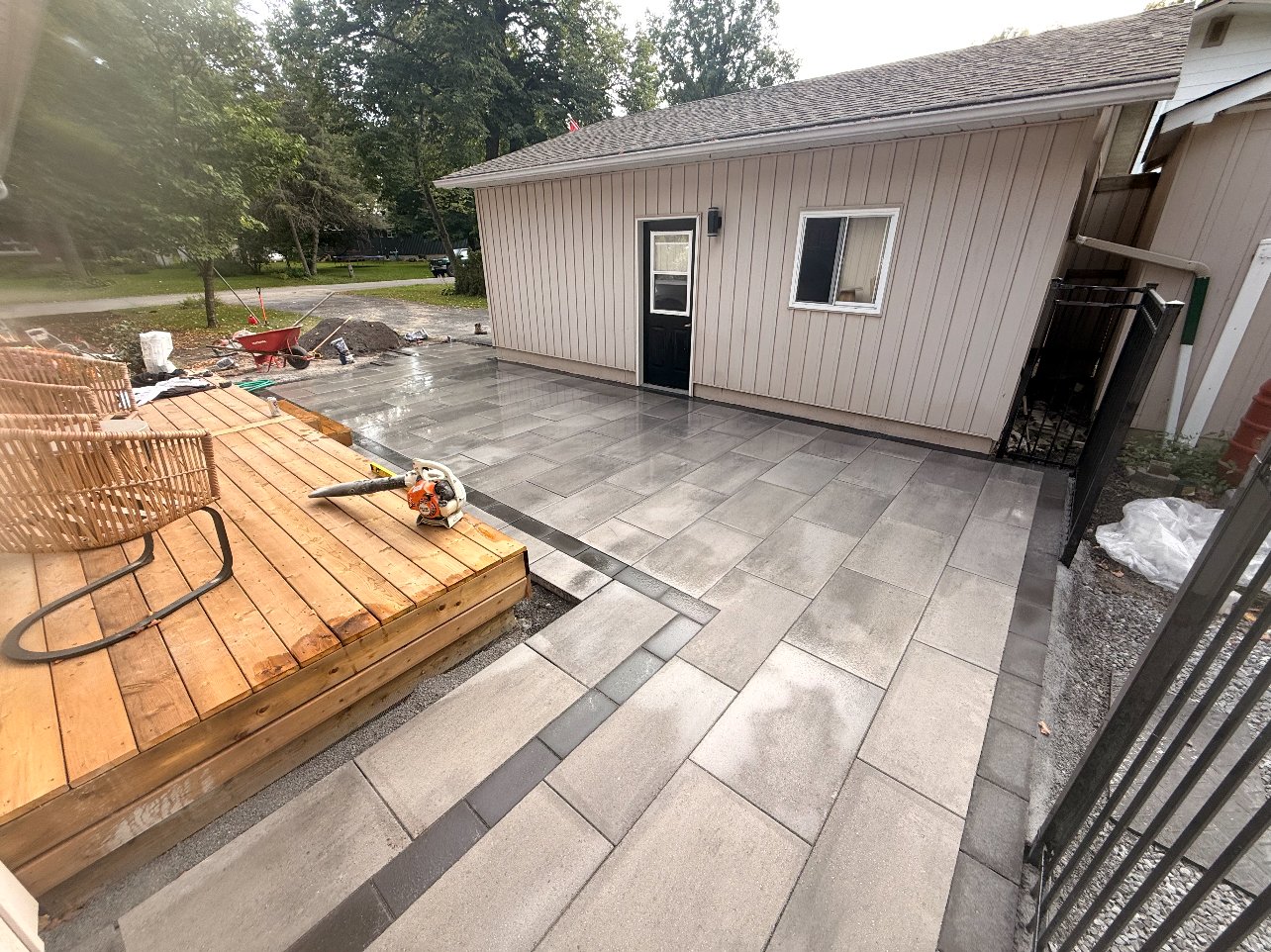 Wide view of the finished two-tone interlock patio with contrast border, job-site photo