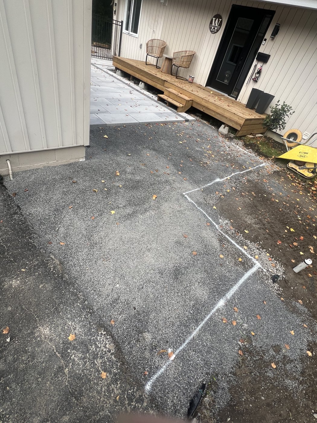 Chalk line marking out the new patio footprint over the old asphalt before excavation